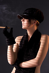 Image showing woman in black astrakhan smoking cigar