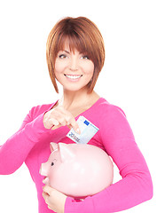 Image showing lovely woman with piggy bank and money