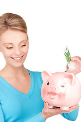 Image showing lovely woman with piggy bank and money