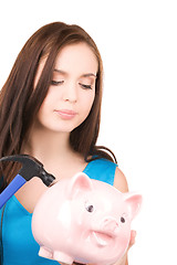 Image showing teenage girl with piggy bank and hammer