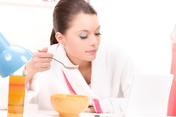 Image showing eating woman with laptop computer