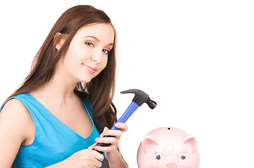 Image showing teenage girl with piggy bank and hammer