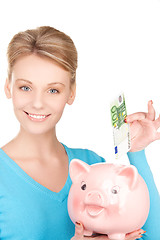 Image showing lovely woman with piggy bank and money