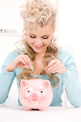 Image showing lovely woman with piggy bank and money