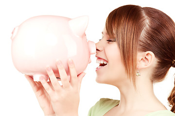 Image showing lovely teenage girl with piggy bank