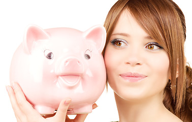 Image showing lovely teenage girl with piggy bank