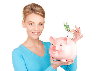 Image showing lovely woman with piggy bank and money