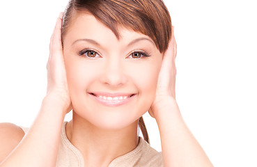 Image showing smiling woman with hands over ears
