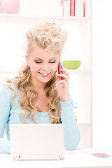 Image showing lovely woman with cell phone and computer