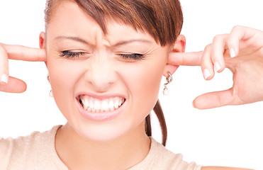 Image showing unhappy woman with fingers in ears