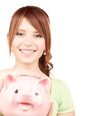 Image showing lovely teenage girl with piggy bank