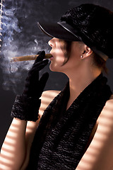 Image showing woman in black astrakhan smoking cigar