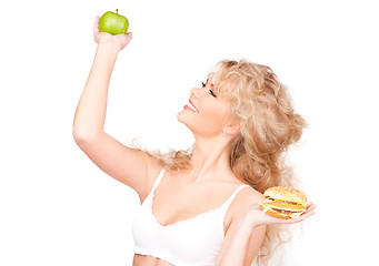 Image showing woman choosing between burger and apple