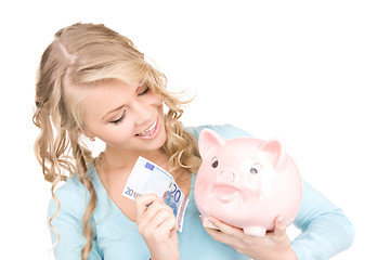 Image showing lovely woman with piggy bank and money