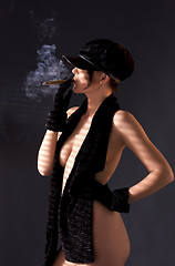 Image showing woman in black astrakhan smoking cigar