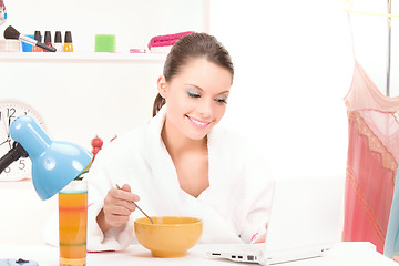 Image showing eating woman with laptop computer