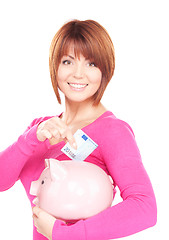 Image showing lovely woman with piggy bank and money