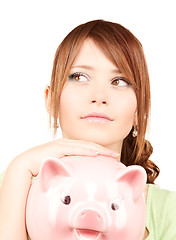 Image showing lovely teenage girl with piggy bank