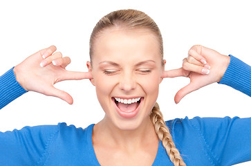 Image showing smiling woman with fingers in ears