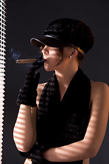 Image showing woman in black astrakhan smoking cigar