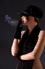Image showing woman in black astrakhan smoking cigar