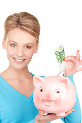 Image showing lovely woman with piggy bank and money