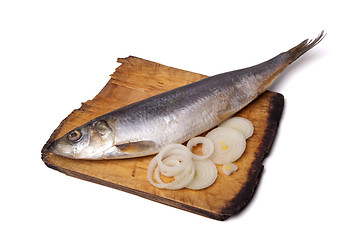 Image showing Herring with onion rings on old wooden cutting board