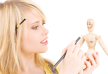 Image showing happy teenage girl with wooden model dummy