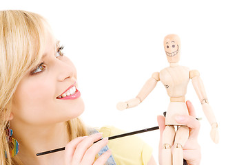 Image showing happy teenage girl with wooden model dummy