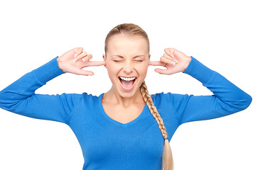 Image showing smiling woman with fingers in ears