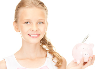 Image showing lovely teenage girl with piggy bank and money