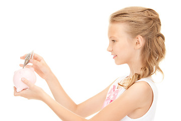 Image showing lovely teenage girl with piggy bank and money