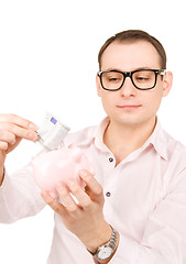 Image showing businessman with piggy bank and money