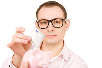 Image showing businessman with piggy bank and money