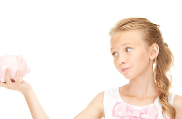 Image showing lovely teenage girl with piggy bank