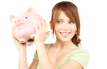 Image showing lovely teenage girl with piggy bank