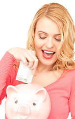 Image showing lovely woman with piggy bank and money