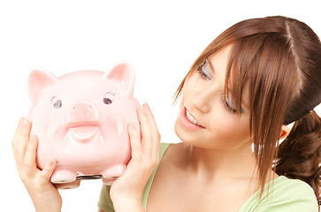 Image showing lovely teenage girl with piggy bank