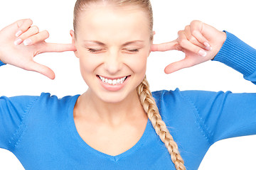 Image showing smiling woman with fingers in ears