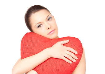 Image showing woman with red heart-shaped pillow over white
