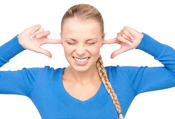 Image showing smiling woman with fingers in ears