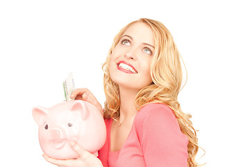 Image showing lovely woman with piggy bank and money