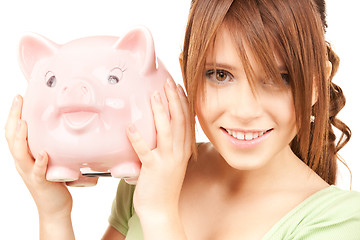 Image showing lovely teenage girl with piggy bank