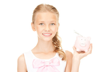 Image showing lovely teenage girl with piggy bank and money
