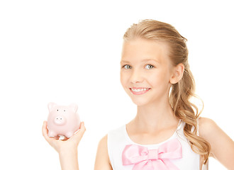 Image showing lovely teenage girl with piggy bank