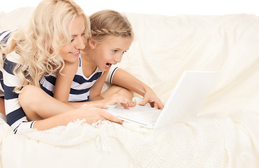 Image showing happy mother and child with laptop computer