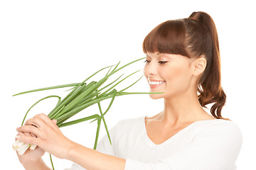 Image showing beautiful housewife with spring onions over white