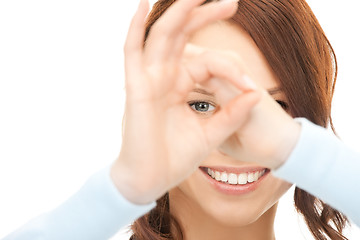 Image showing lovely woman looking through hole from fingers