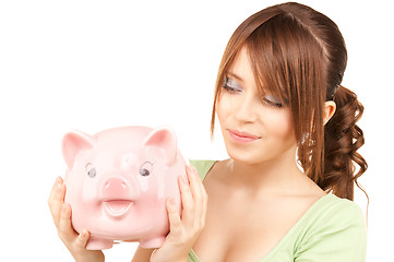 Image showing lovely teenage girl with piggy bank