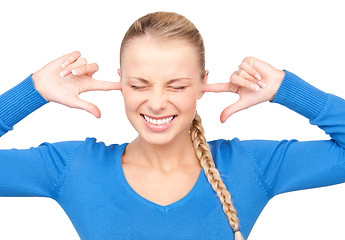 Image showing smiling woman with fingers in ears